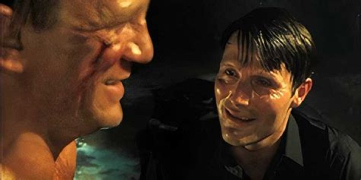 Le Chiffre torturing James Bond while both of them sweat excessively.